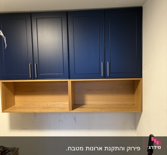 ארונות כחולים מותקנים על קיר עם כלים על שולחן קטן